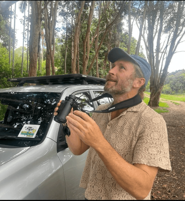 Birding guide with binoculars in natural setting